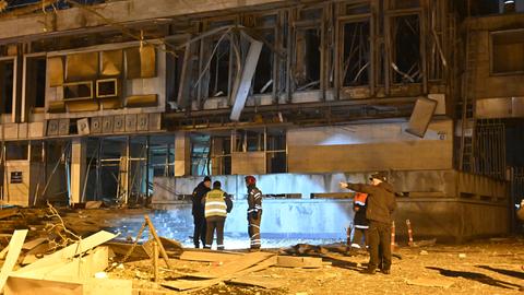 Feuerwehrleute stegen vor einem Gebäude in Charkiw, das durch einen russischen Drohnenangriff beschädigt wurde.