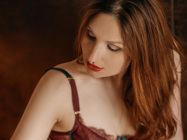 Luisa mit langen rötlichen Haaren und in Dessous.