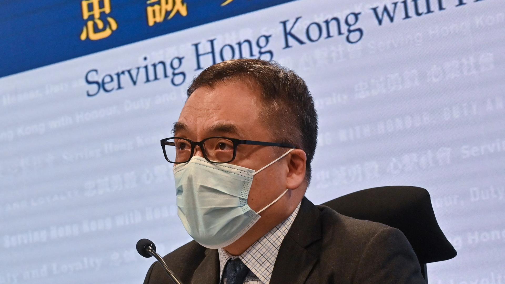 Li Kwai-wah, Leiter des National Security Department Hong Kong, sitzt mit Mund-Nasen-Schutz bei einer Pressekonferenz.