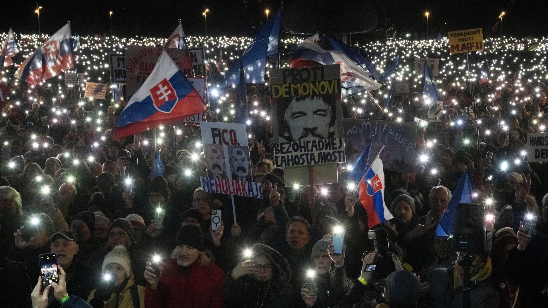 Bei einer pro-europäischen Demonstration in der Slowakei halten die Demonstranten in der Dunkelheit Lampen in die Höhe und kreieren rund um ihre Transparente und Flaggen ein Lichtermeer.