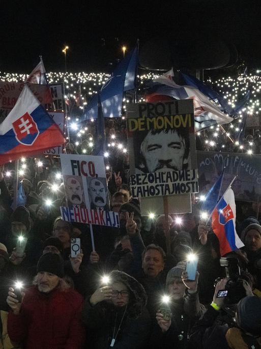 Bei einer pro-europäischen Demonstration in der Slowakei halten die Demonstranten in der Dunkelheit Lampen in die Höhe und kreieren rund um ihre Transparente und Flaggen ein Lichtermeer.