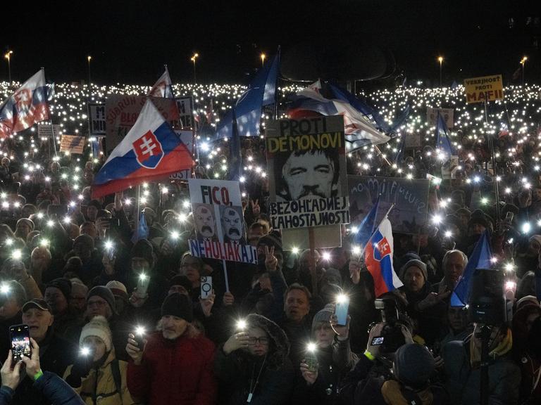 Bei einer pro-europäischen Demonstration in der Slowakei halten die Demonstranten in der Dunkelheit Lampen in die Höhe und kreieren rund um ihre Transparente und Flaggen ein Lichtermeer.