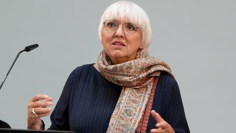 Kulturstaatsministerin Claudia Roth (Grüne) steht an einem Rednerpult und spricht. 