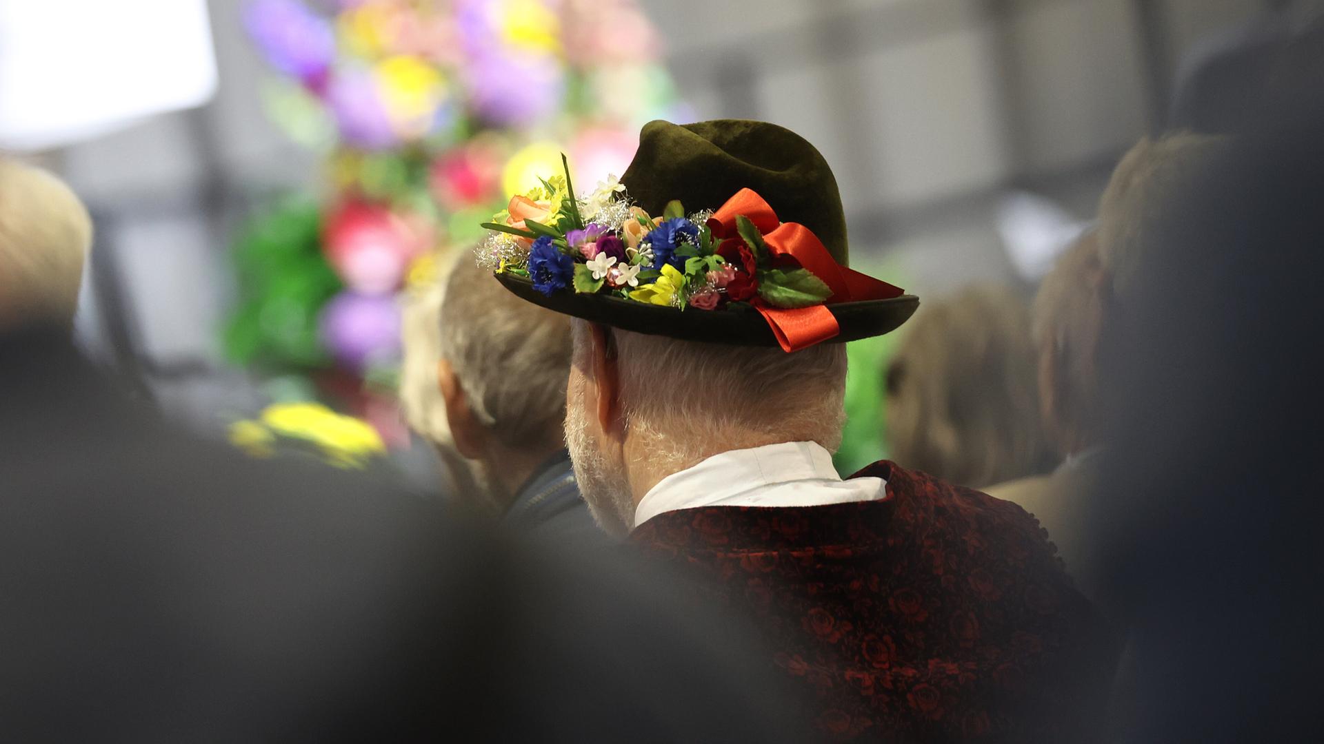 Ein Besucher in Tracht sitzt bei der Eröffnung des 74. Sudetendeutschen Tages.