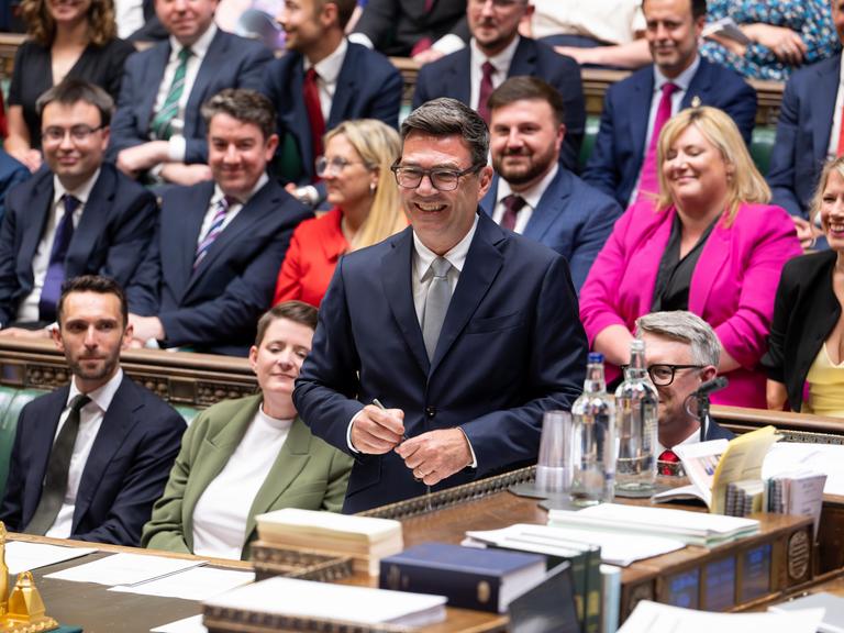 Andy Burnham steht während seiner Vereidigung als Abgeordneter im britischen Unterhaus und lächelt. Andy Burnham steht während seiner Vereidigung als Abgeordneter im britischen Unterhaus und lächelt.