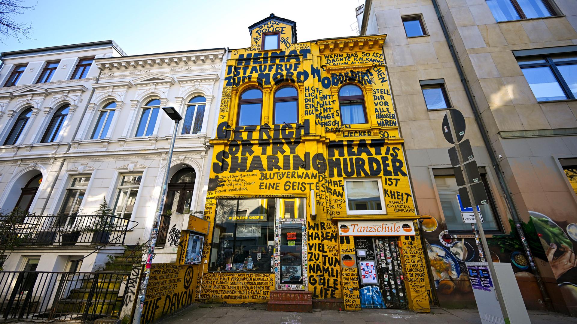 Der Buchladen "Golden Shop" in der Fehrfeld-Straße mit gelber Fassade und Graffitti-Aufschriften