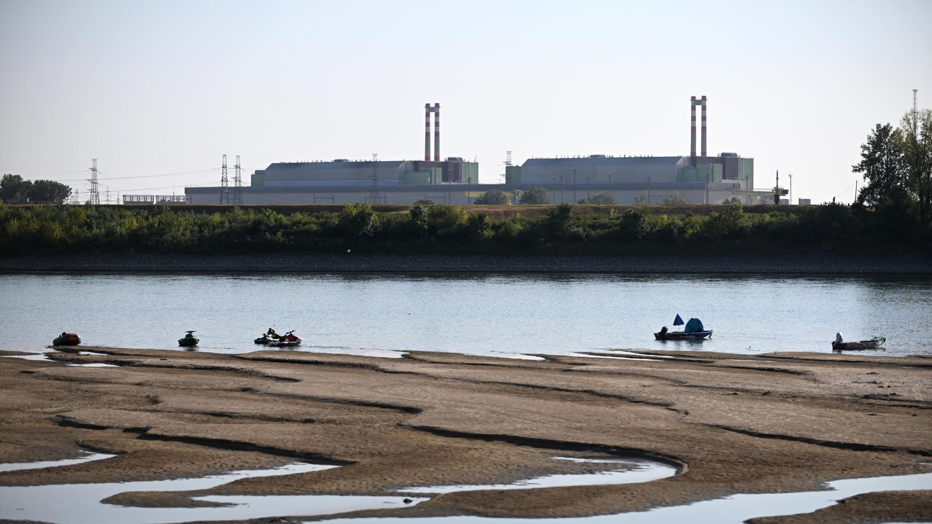 Das ungarische Atomkraftwerk Paks vom Ufer der Donau aus fotografiert. Der Fluss führt wenig Wasser und Sandbänke treten hervor. Das ungarische Atomkraftwerk Paks vom Ufer der Donau aus fotografiert. Der Fluss führt wenig Wasser und Sandbänke treten hervor.