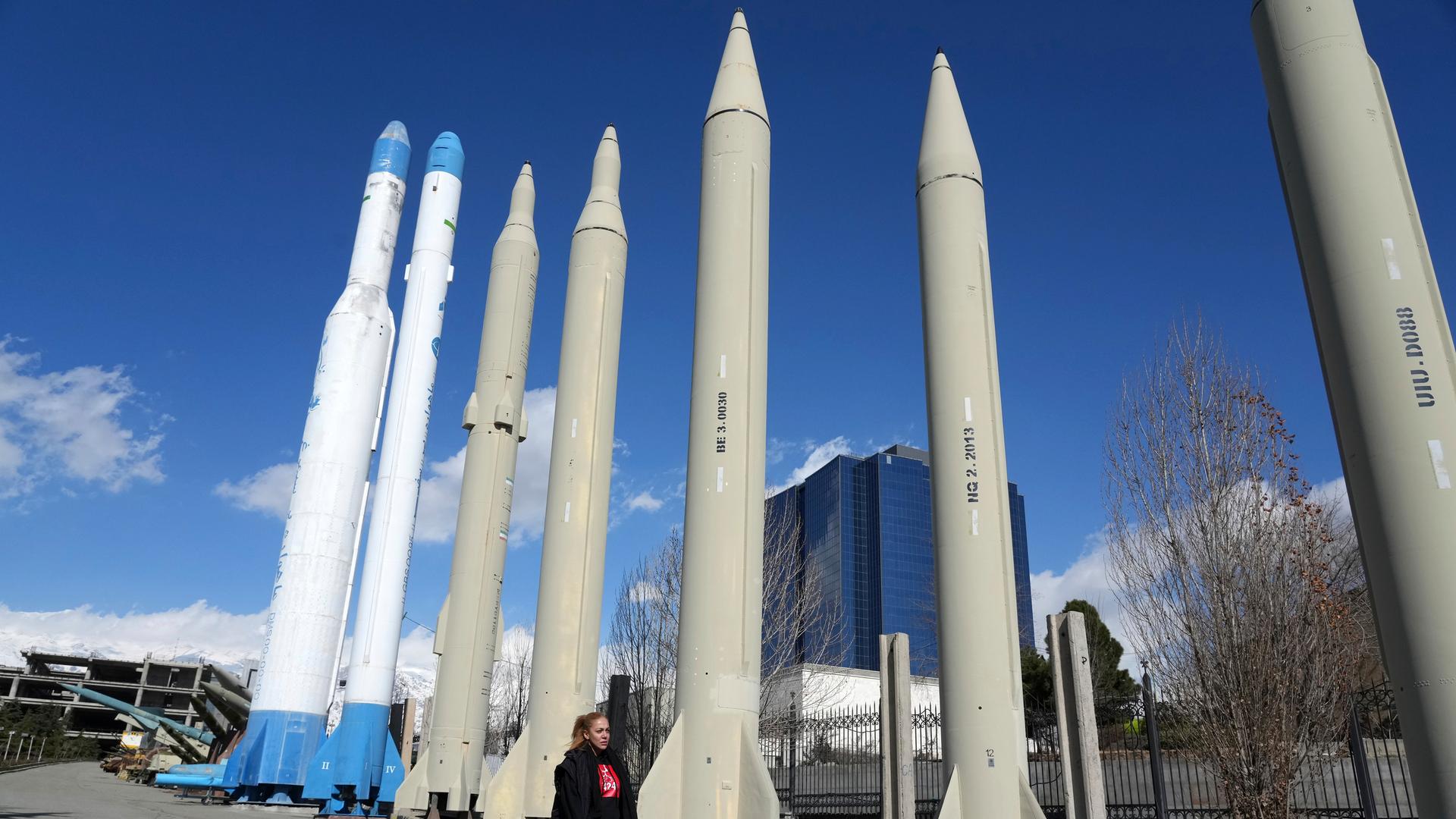 Iran, Teheran: Eine Frau geht in einem Erholungsgebiet im Norden Teherans an den im Iran produzierten Raketen und Satellitenträgern vorbei, die in einer Dauerausstellung gezeigt werden. 