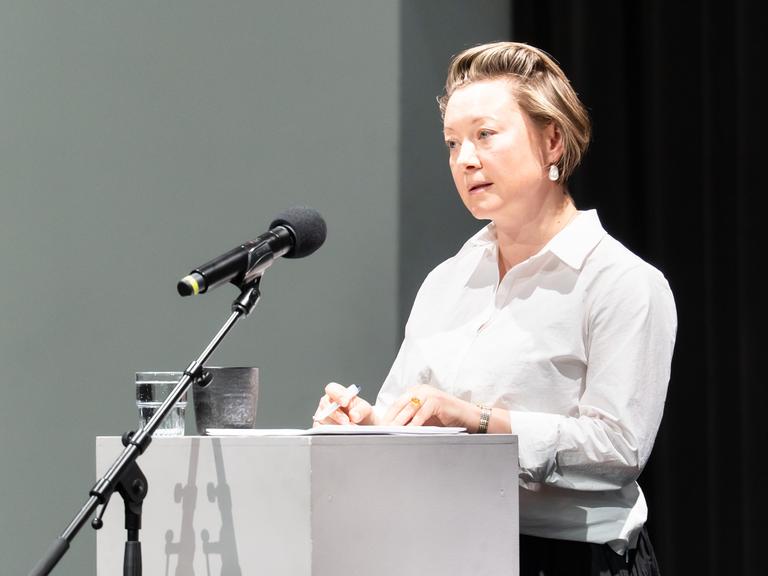 Valzhyna Mort steht an einem Sprecherpult beim Poesiefestival Berlin 2026.