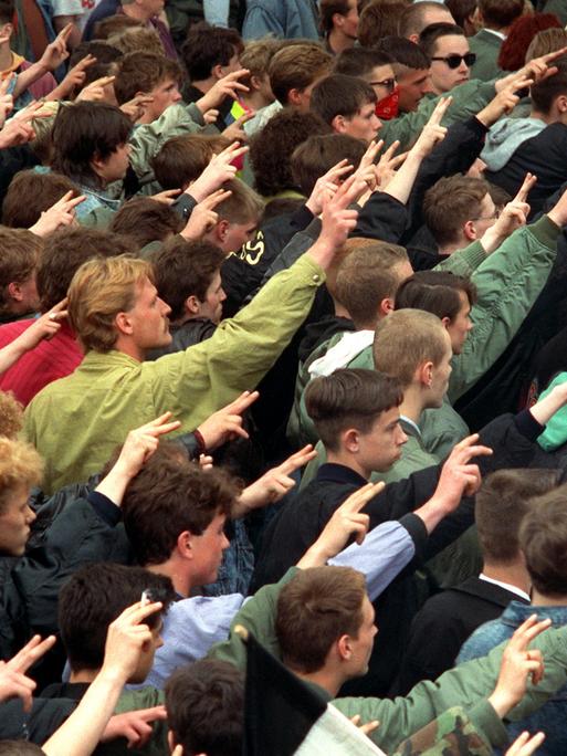 Teilnehmer eines "Trauermarsches" in Dresden für den erschossenen Neonazi Rainer Sonntag. Viele junge Männer bilden einen Pulk und heben ihre Hände zum Hitlergruß, wobei sie Zeige- und Mittelfinger spreizen.