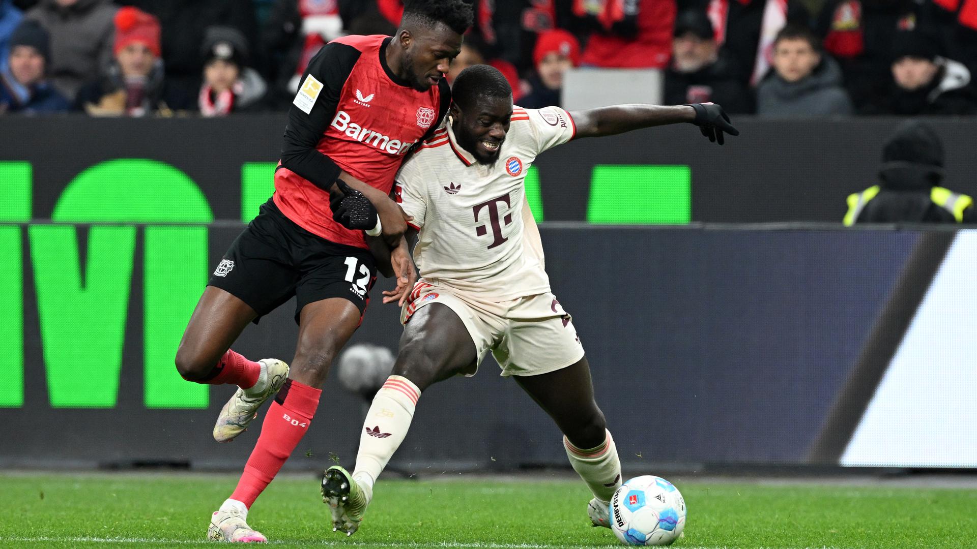 Das Bild zeigt einen Zweikampf um den Ball im Fußball-Bundesliga-Spiel Bayer Leverkusen gegen Bayern München.