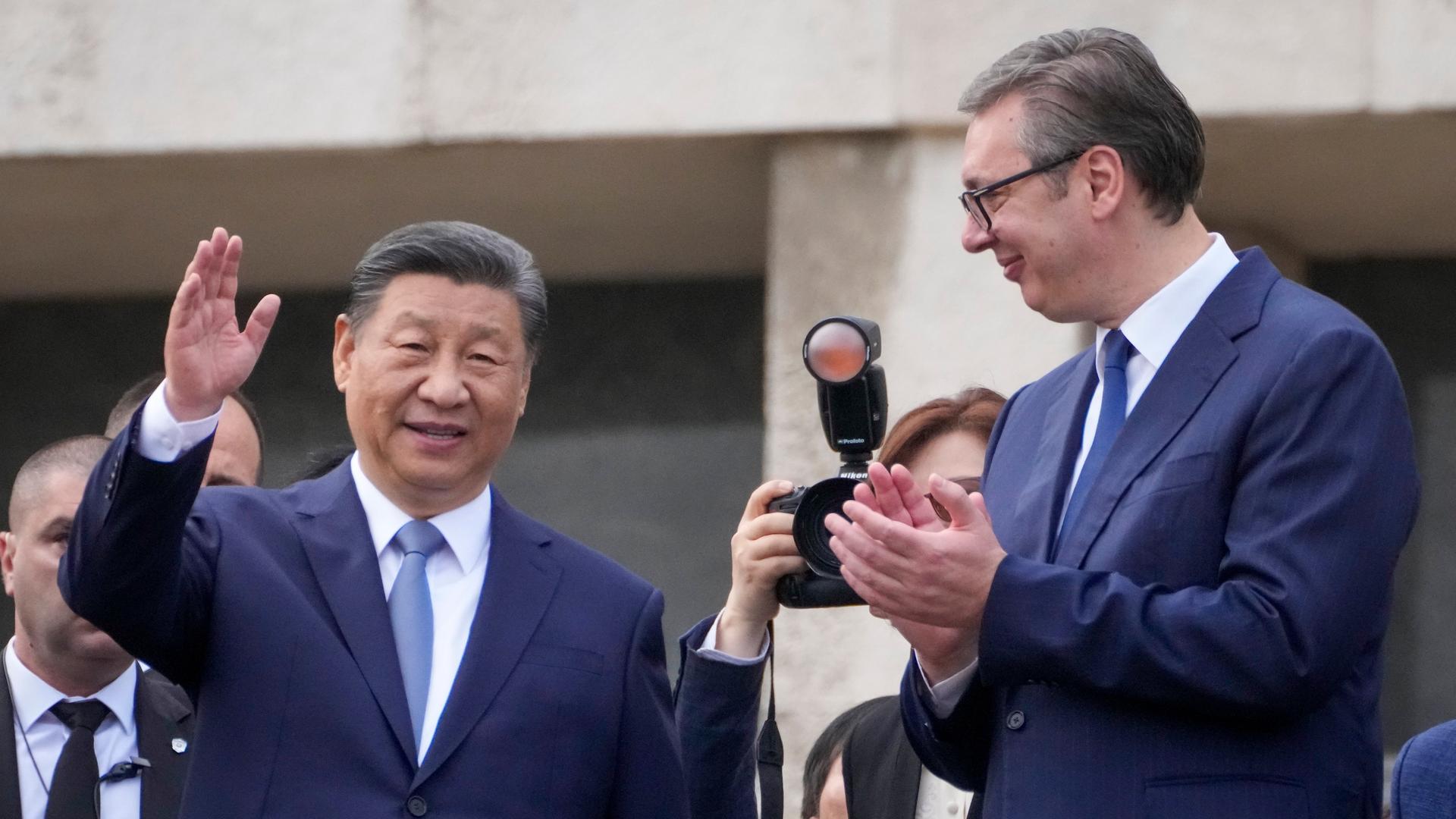 Der chinesische Präsident Xi Jinping begrüßt den serbischen Präsidenten Vucic. Xi grüßt mit erhobener Hand die Menge.