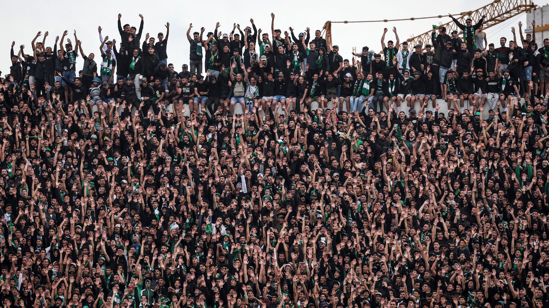 Fans im Stadion von Raja Casablanca, beim Spiel des marokkanischen Vereins gegen den ägyptischen Club Al Ahly. Die Ränge sind sehr voll und noch oberhalb der Absperrung stehen Menschen.