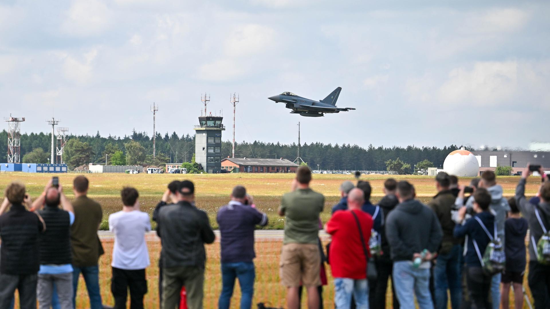 Besucher beobachten einen Eurofighter. Besucher beobachten einen Eurofighter.