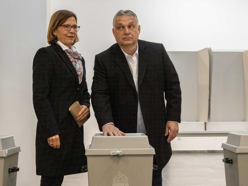 Der ungarische Ministerpräsident Viktor Orban und seine Frau Aniko Levai nach der Stimmabgabe zu den Parlamentswahlen am 3. April 2022 in Budapest. Orban legt seine Hand auf die Wahlurne.