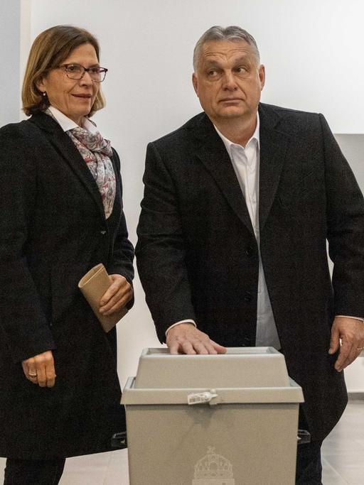 Der ungarische Ministerpräsident Viktor Orban und seine Frau Aniko Levai nach der Stimmabgabe zu den Parlamentswahlen am 3. April 2022 in Budapest. Orban legt seine Hand auf die Wahlurne.