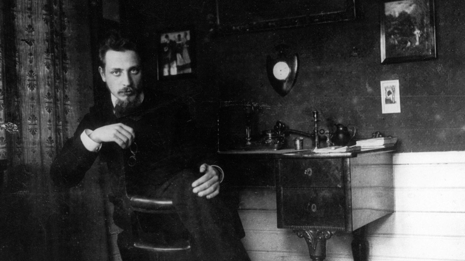 Historisches schwarz-weiß Foto: Rainer Maria Rilke sitzt an seinem Schreibtisch, ca. 1905.