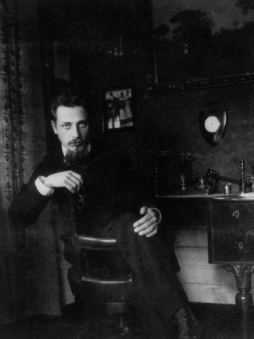 Historisches schwarz-weiß Foto: Rainer Maria Rilke sitzt an seinem Schreibtisch, ca. 1905.