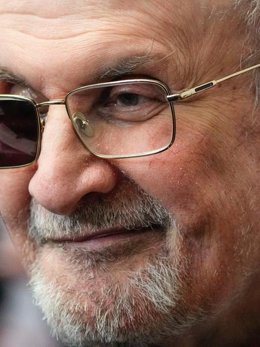 Salman Rushdie mit einer Brille mit einer verdunkelten Seite.