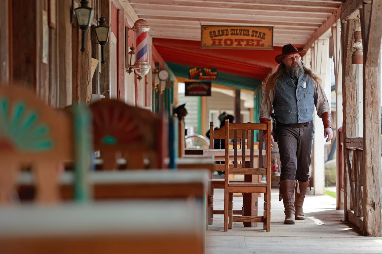 Ein Mitarbeiter der Westernstadt Pullman City Harz in Hasselfelde geht an einer Aussenbestuhlung vorbei (2023).
