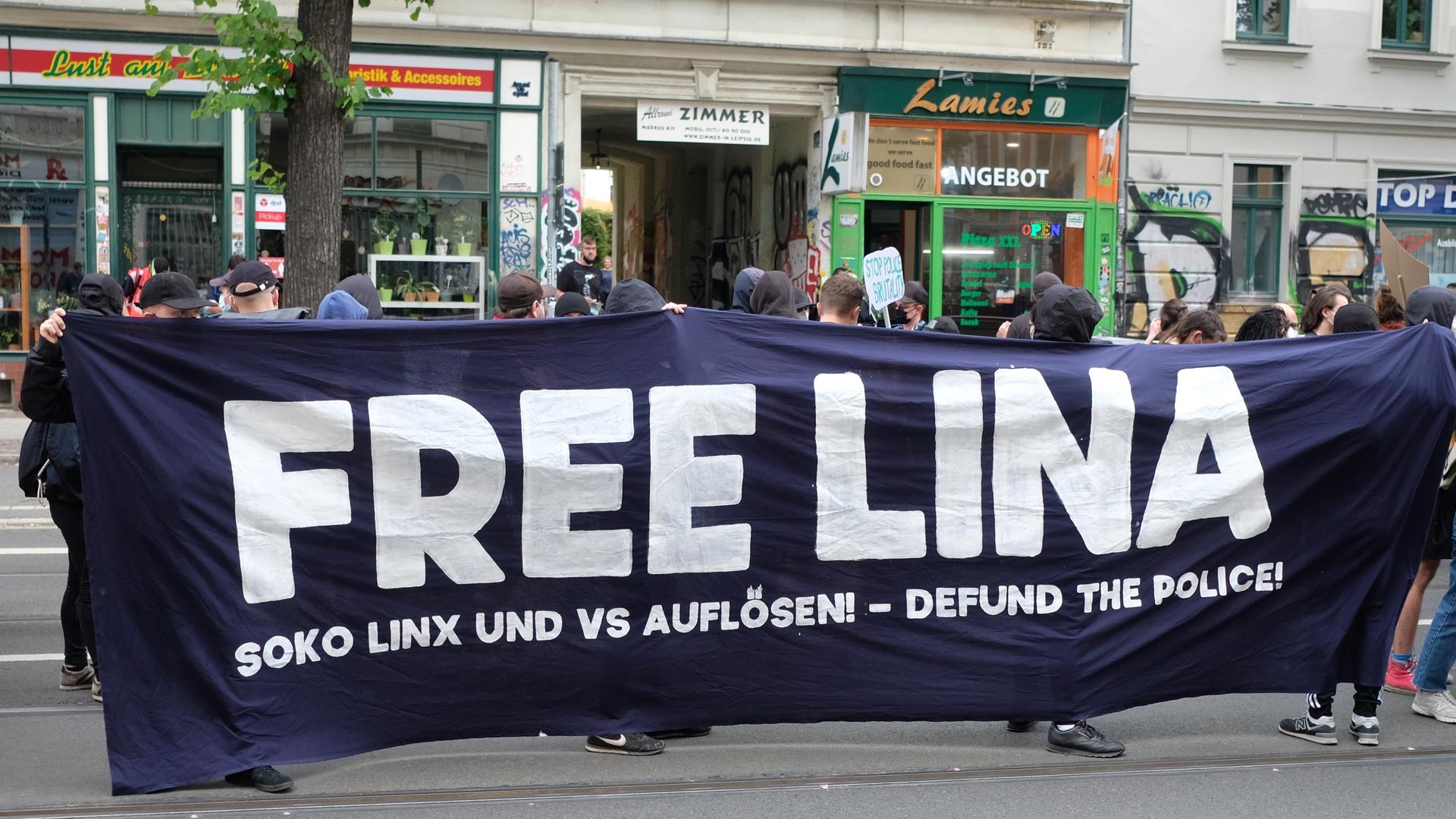 Linke Demonstration halten ein schwarzes Banner mit weißen Lettern: "Free Lina"