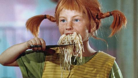 Pippi Langstrumpf schneidet sich einen aus ihrem Mund hängenden Bart auf Spaghetti mit der Schere ab