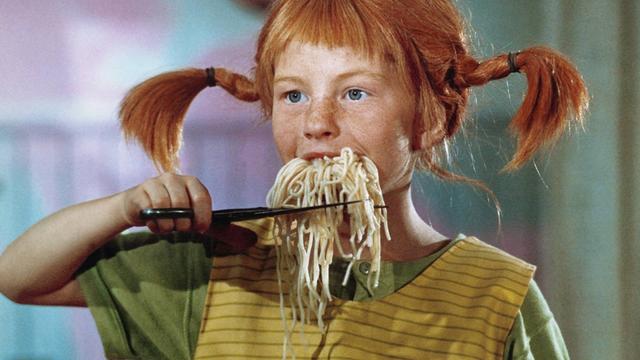 Pippi Langstrumpf schneidet sich einen aus ihrem Mund hängenden Bart auf Spaghetti mit der Schere ab
