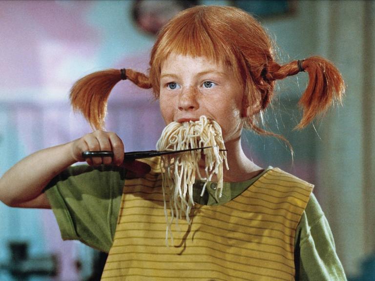 Pippi Langstrumpf schneidet sich einen aus ihrem Mund hängenden Bart auf Spaghetti mit der Schere ab