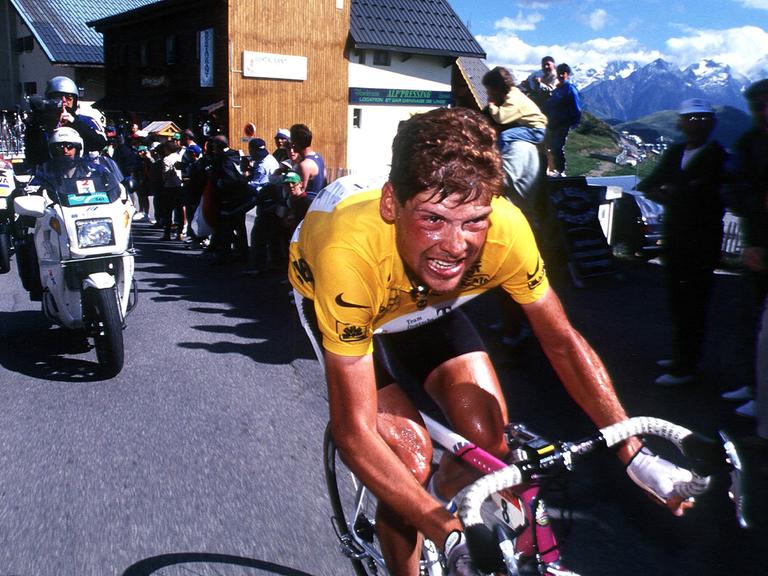 Das Bild zeigt das Jan Ullrich im Gelben Trikot auf seinem Fahrrad während der Tour de France 1997.