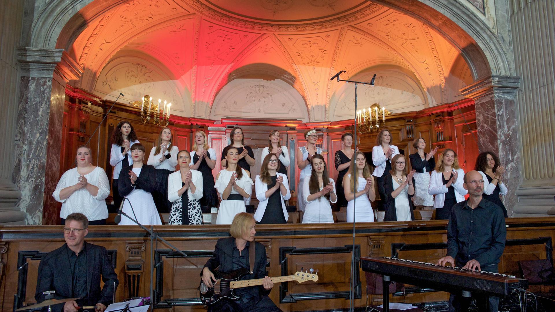 In einer Kirche singt ein Gospelchor begleitet von drei Musikern an Schlagzeug, Gitarre und Keyboard In einer Kirche singt ein Gospelchor begleitet von drei Musikern an Schlagzeug, Gitarre und Keyboard