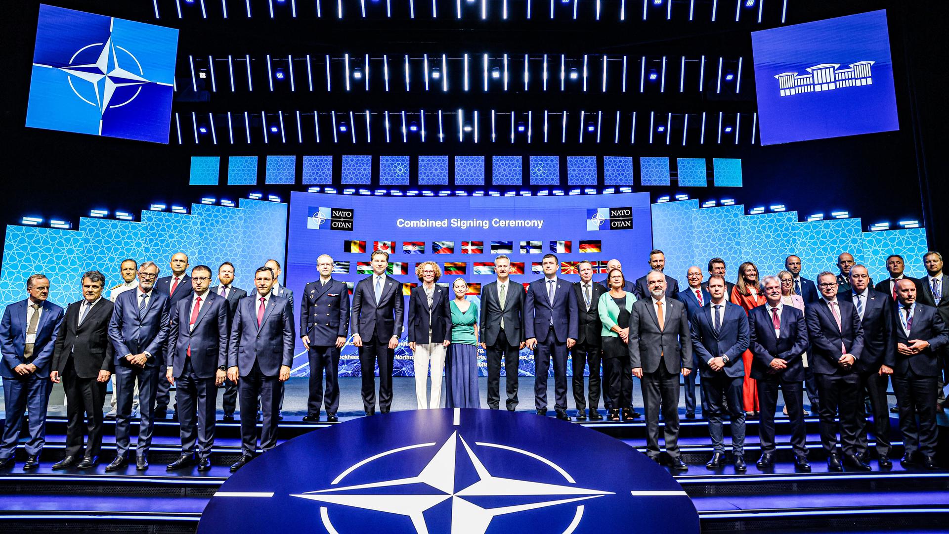 NATO-Gipfeltreffen des Verteidigungsindustrieforums (NSDIF) im NATO-Kongress in Ankara. Die große Versammlung steht vor einem digitalen Hintergrund mit den Nationalflaggen der Bündnispartner.