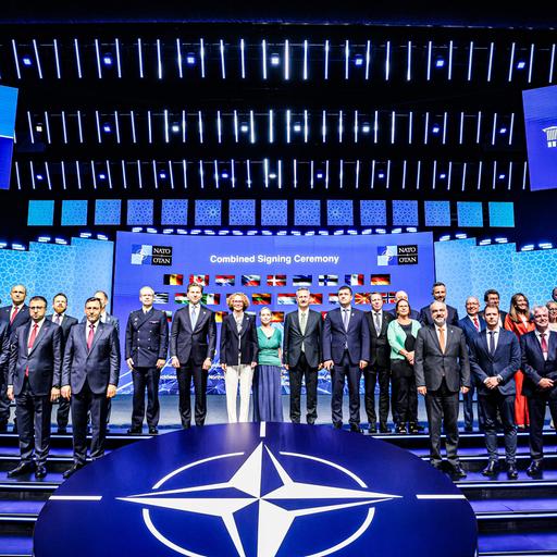 Das Bidl zeigt das Verteidigungsindustrieforum des NATO-Gipfeltreffens in Ankara. Die Vertreterinnen und Vertreter stehen vor einem digitalen Hintergrund mit den Nationalflaggen der Bündnispartner.