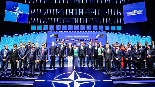 Das Bidl zeigt das Verteidigungsindustrieforum des NATO-Gipfeltreffens in Ankara. Die Vertreterinnen und Vertreter stehen vor einem digitalen Hintergrund mit den Nationalflaggen der Bündnispartner.