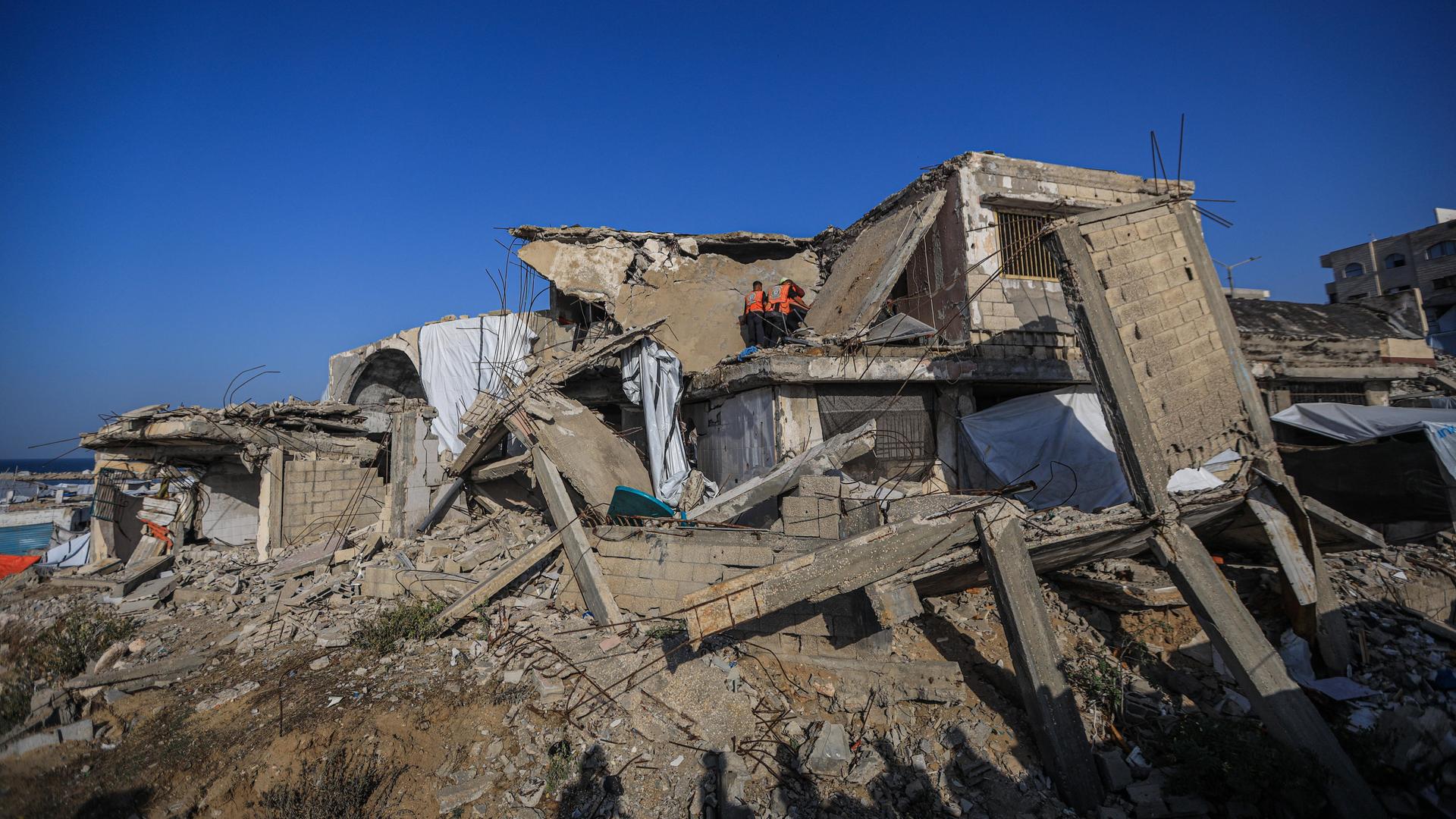Menschen inspizieren ein von einem israelischen Angriff völlig zerstörtes Haus.