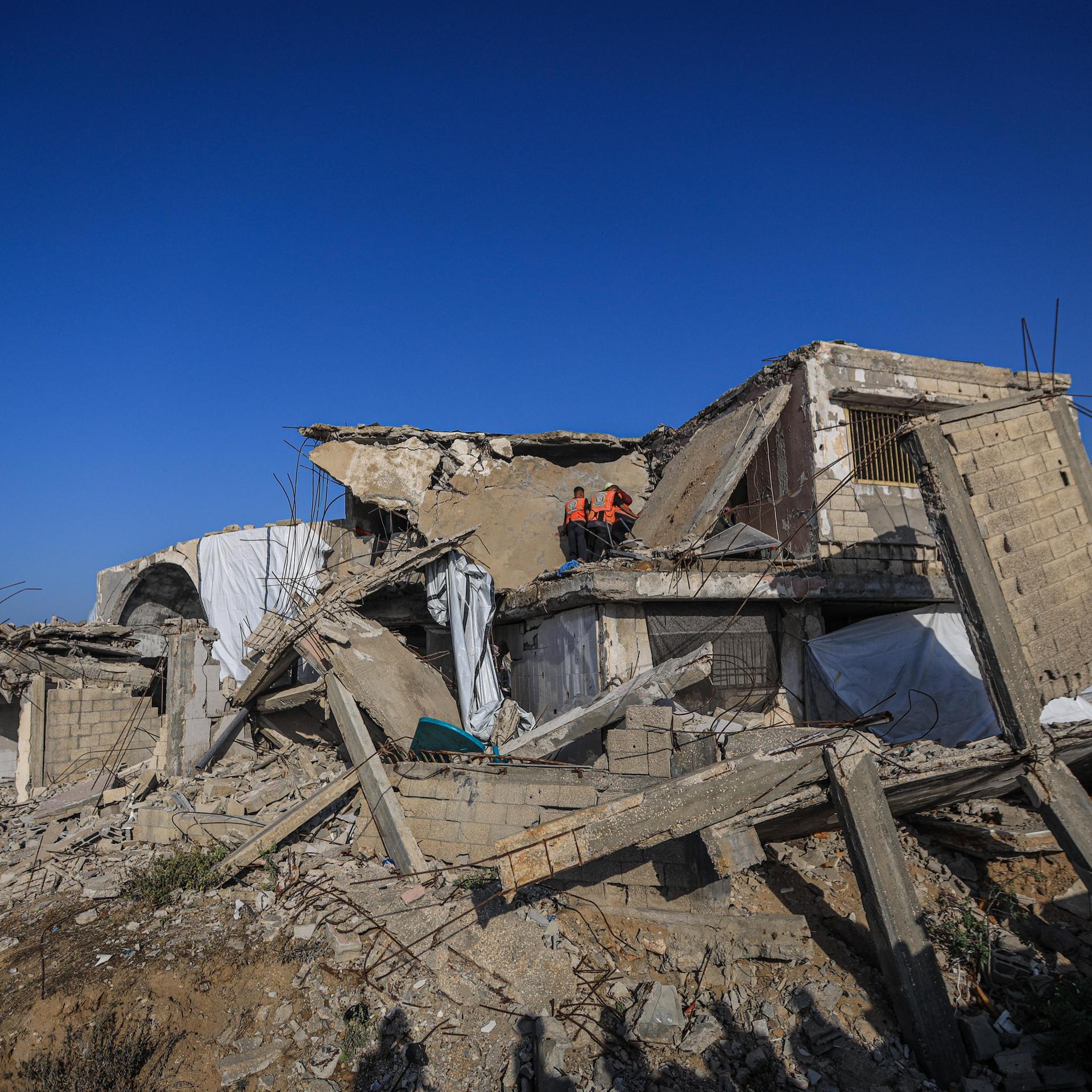 Menschen inspizieren ein von einem israelischen Angriff völlig zerstörtes Haus.