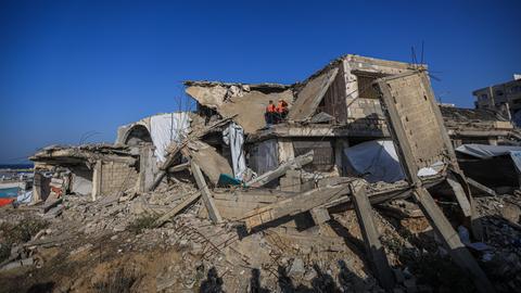 Menschen inspizieren ein von einem israelischen Angriff völlig zerstörtes Haus.