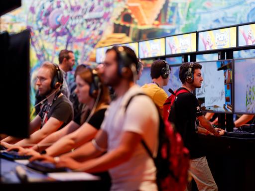 Menschen spielen auf der Gamescom am Computer