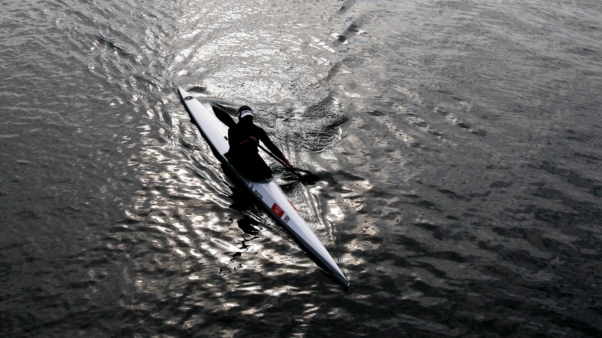 Ein Kanute aus dem Iran paddelt auf einem ruhigen Gewässer. 