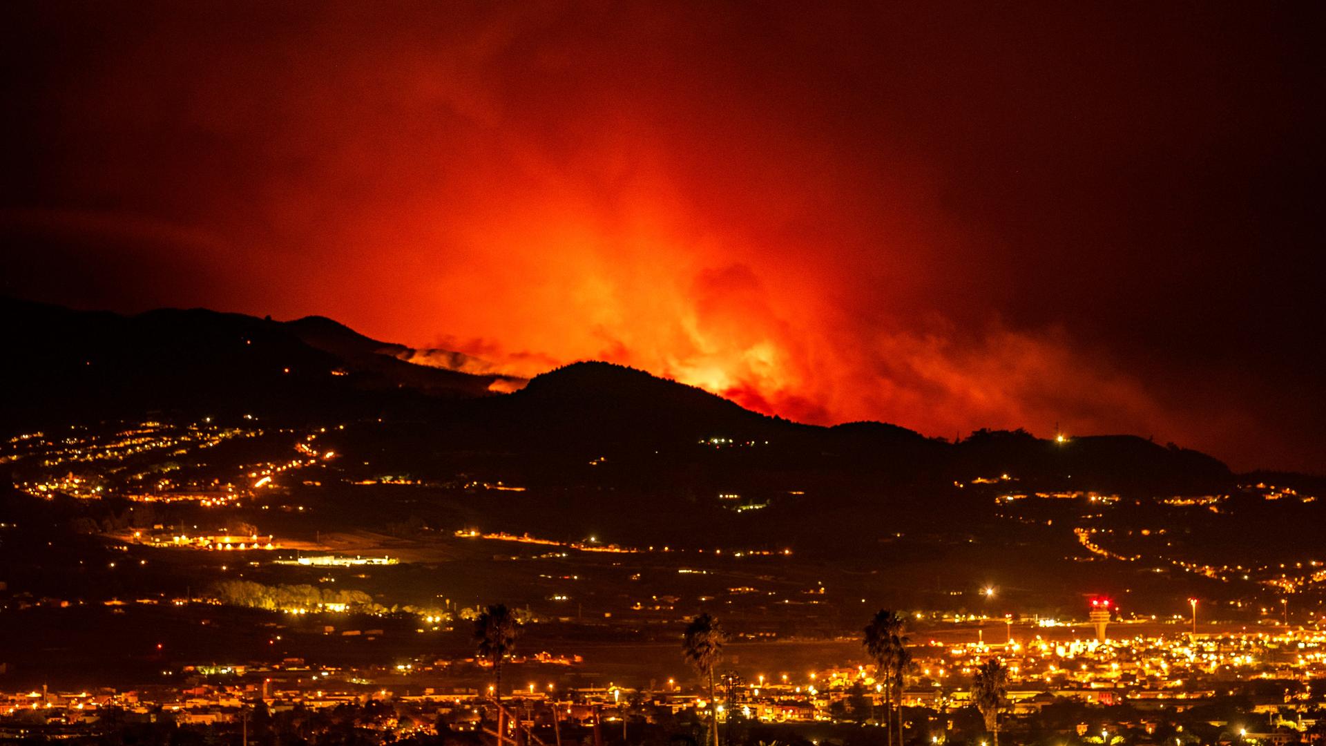 Auf der spanischen Kanareninsel Teneriffa sind am Horizont Flammen zu sehen, während sich das Feuer durch den Wald auf die Stadt La Laguna und den Flughafen Los Rodeos zubewegt.