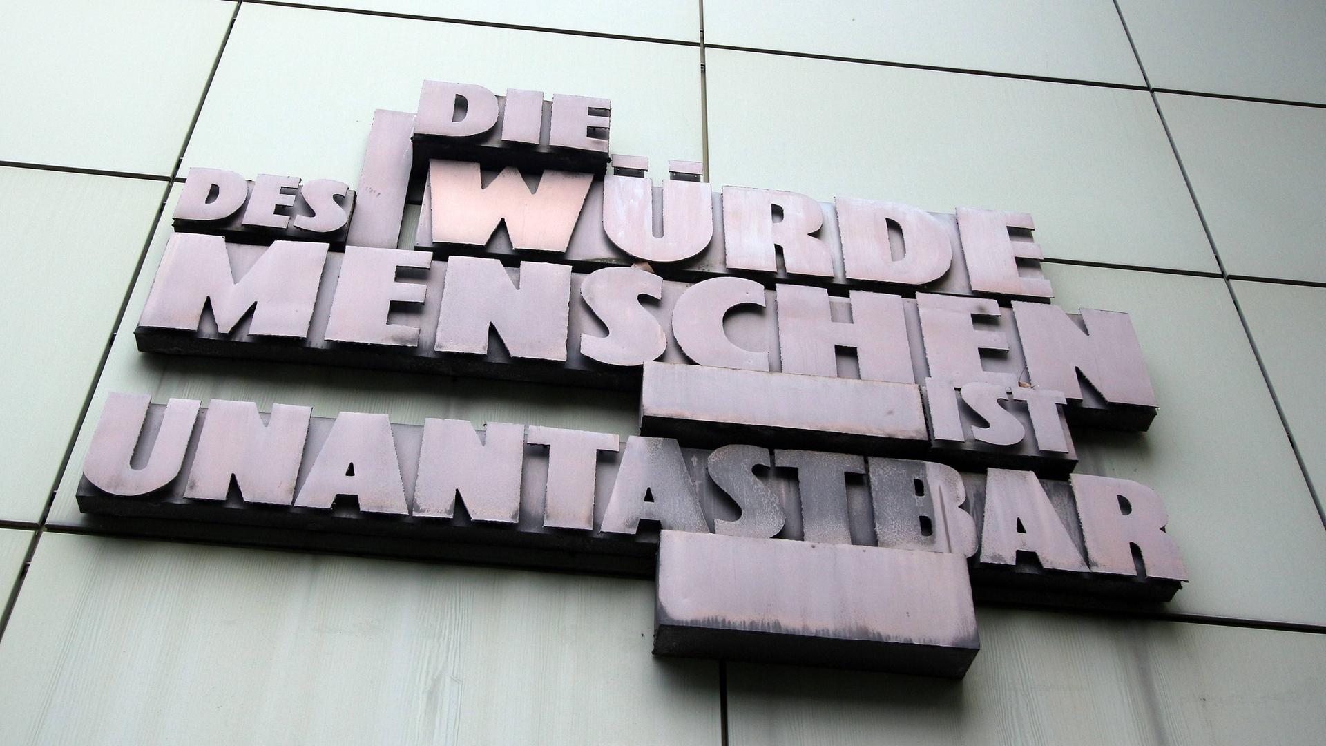 Schriftzug mit Artikel eins des Grundgesetzes der Bundesrepublik Deutschland "Die Würde des Menschen ist unantastbar" an der Fassade der Staatsanwaltschaft im Justizzentrum in Frankfurt am Main