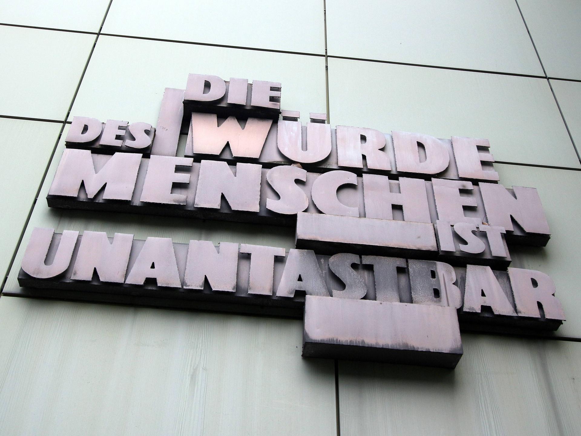 Schriftzug mit Artikel eins des Grundgesetzes der Bundesrepublik Deutschland "Die Würde des Menschen ist unantastbar" an der Fassade der Staatsanwaltschaft im Justizzentrum in Frankfurt am Main