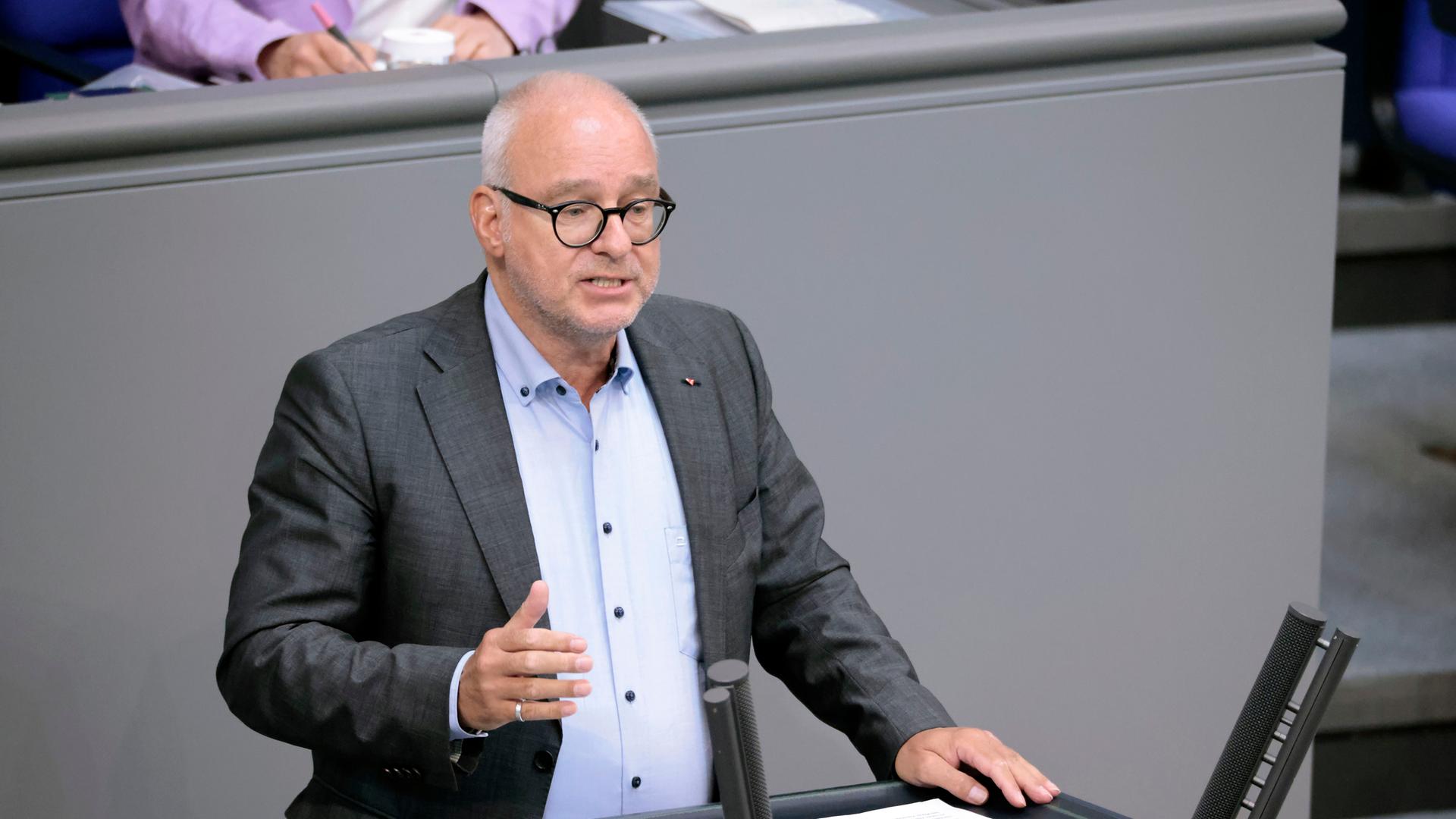 Matthias W. Birkwald steht an einem Redenrpult im Deutschen Bundestag