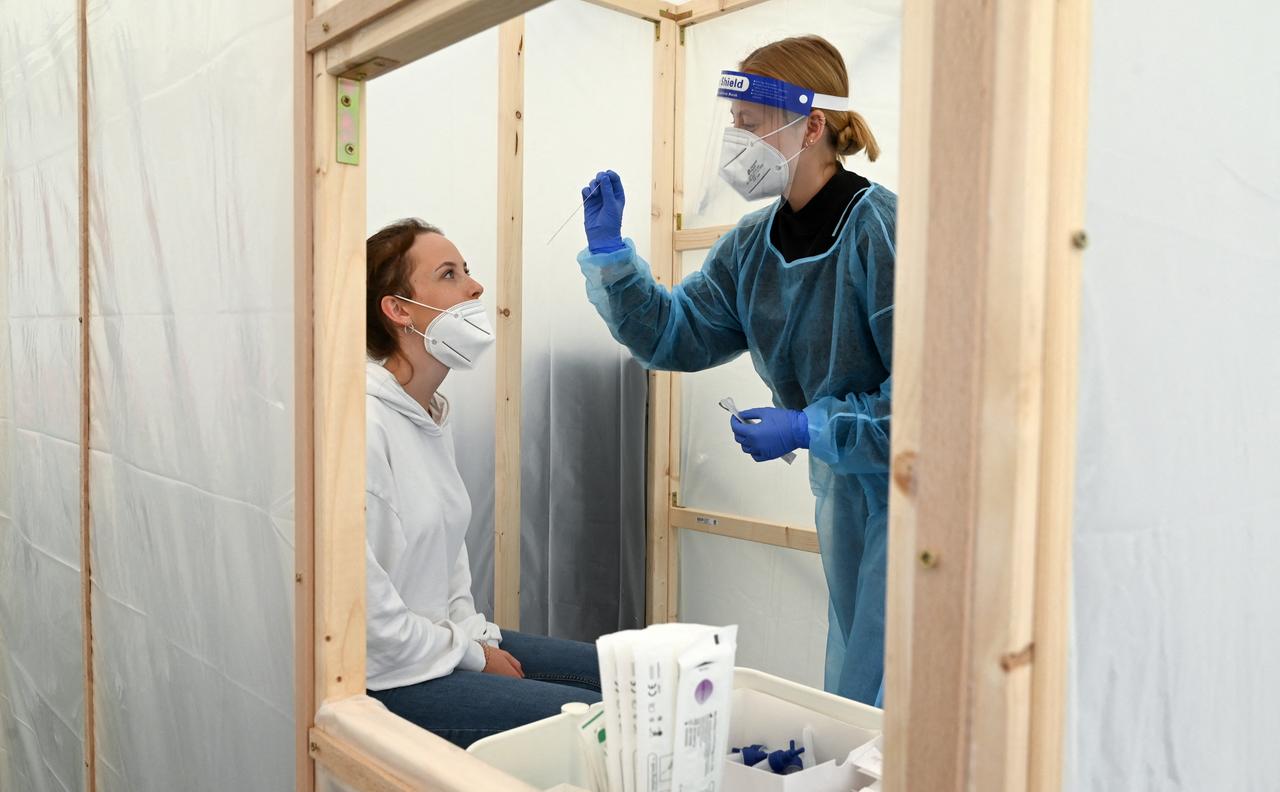 Eine Frau lässt sich in einer provisorischen Holzkabine auf den Coronavirus testen.