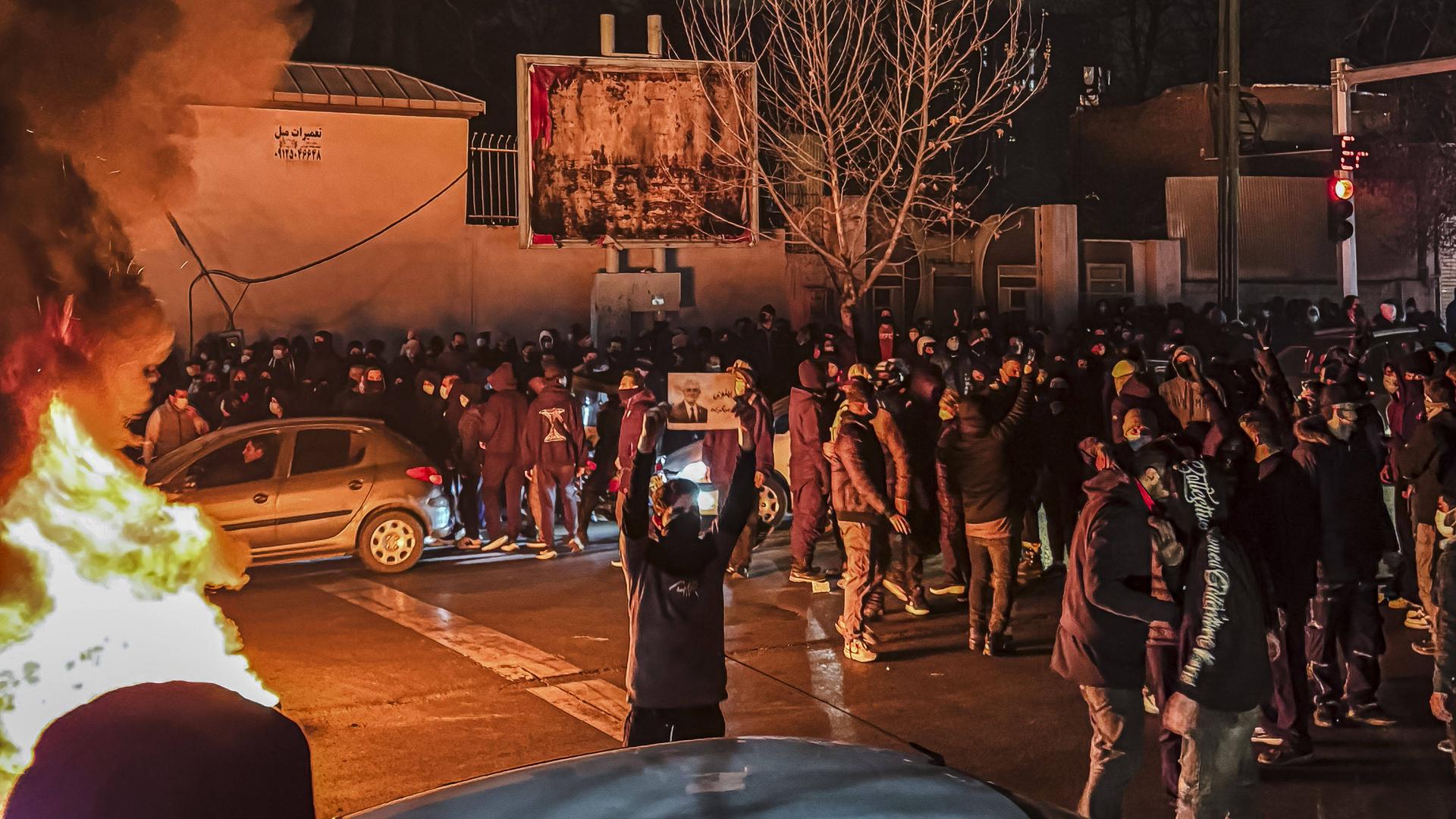 Menschen versammeln sich während einer Protestaktion in Teheran und blockieren dabei eine Straße. 
