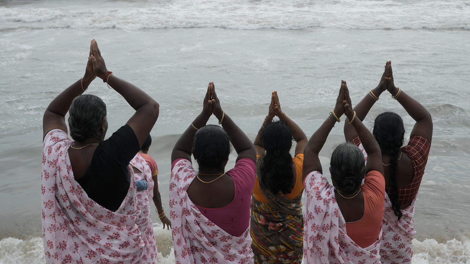 5 Frauen blicken auf das Meer. Sie beten.