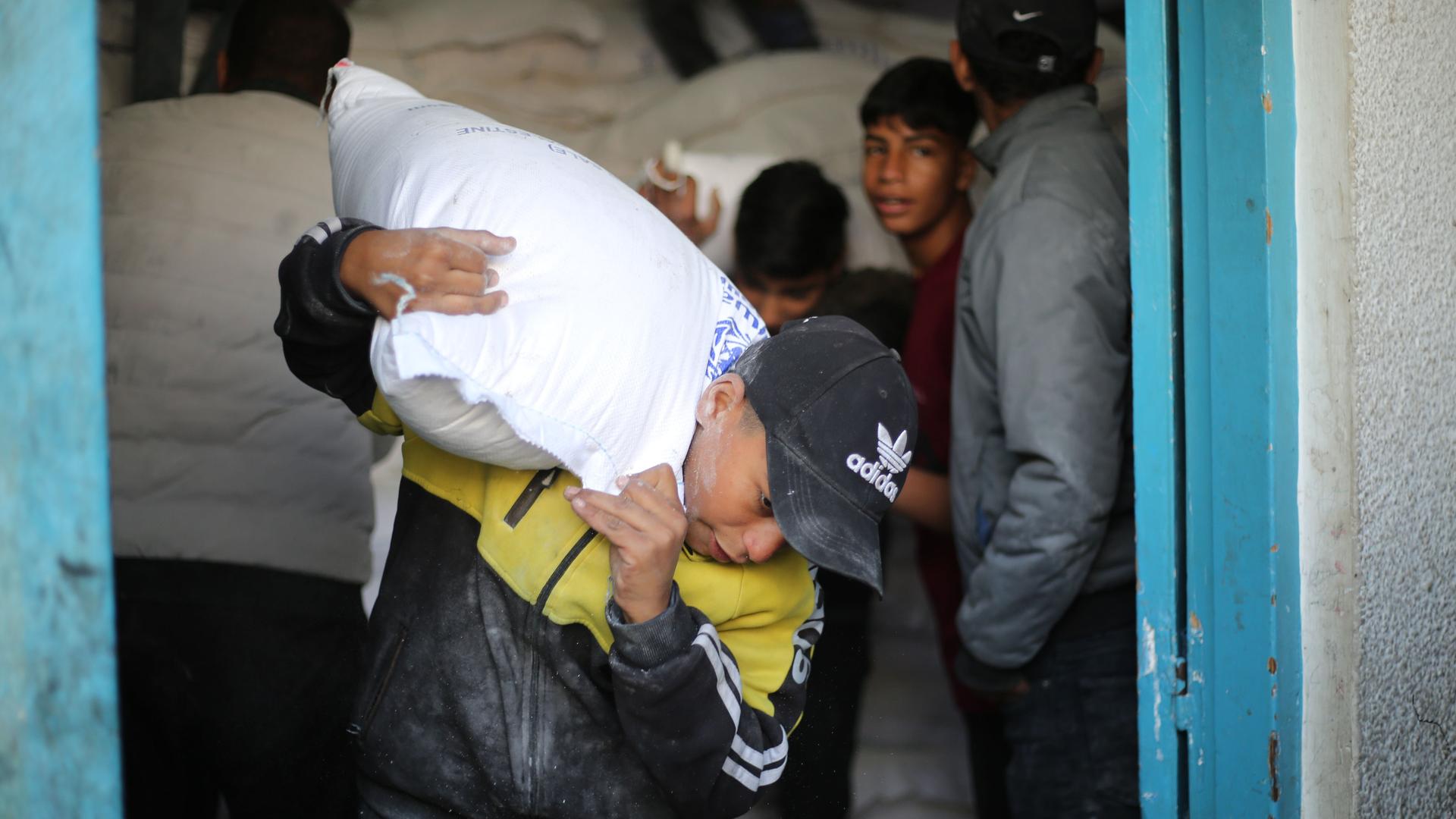 Ein Junge im Gazastreifen schleppt einen Sack mit Hilfsgütern der Organisation UNRWA.