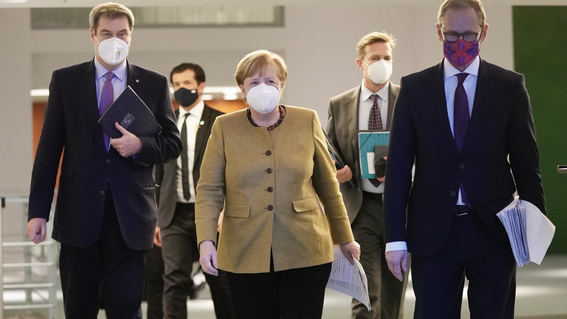 Angela Merkel geht neben Markus Söder sowie Michael Müller zu der Pressekonferenz nach den Beratungen von Bund und Ländern über weitere Corona-Maßnahmen.