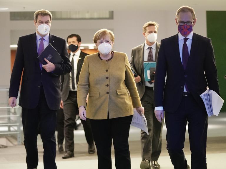 Angela Merkel geht neben Markus Söder sowie Michael Müller zu der Pressekonferenz nach den Beratungen von Bund und Ländern über weitere Corona-Maßnahmen.