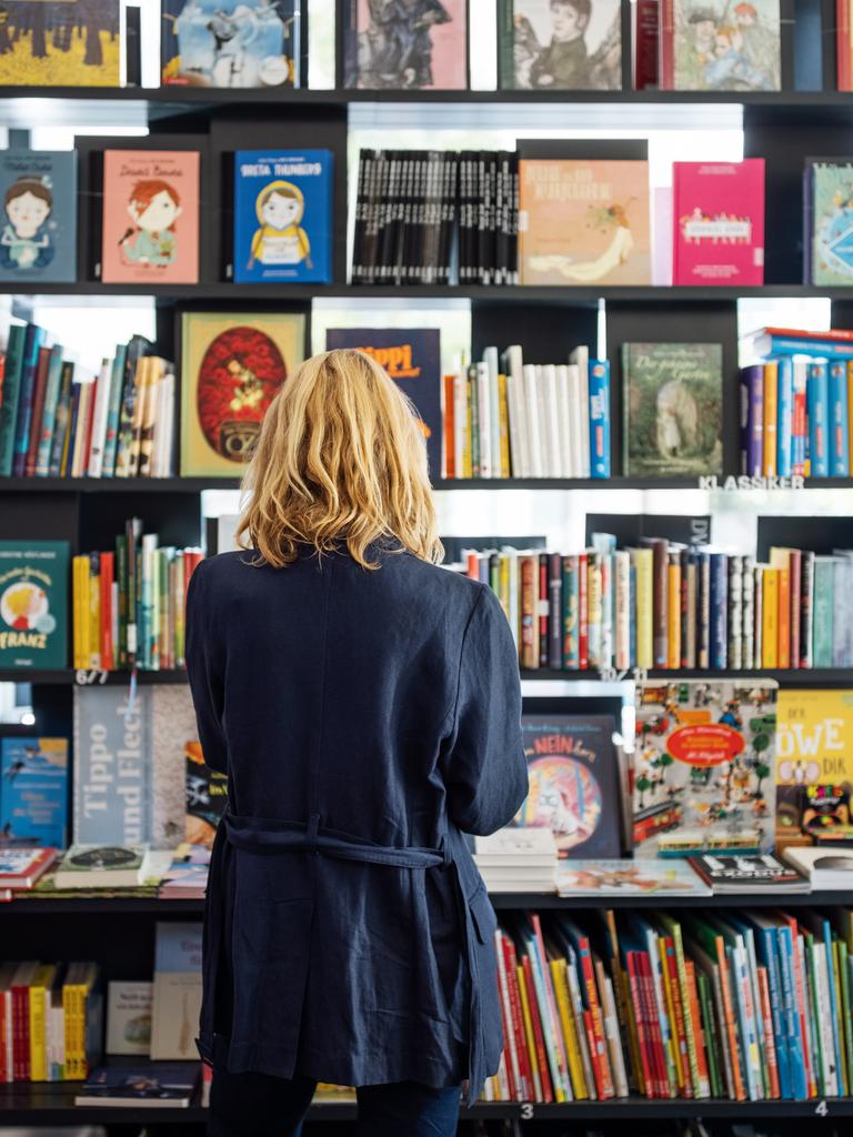 Eine Frau steht vor einem Bücherregal in einem Buchladen.