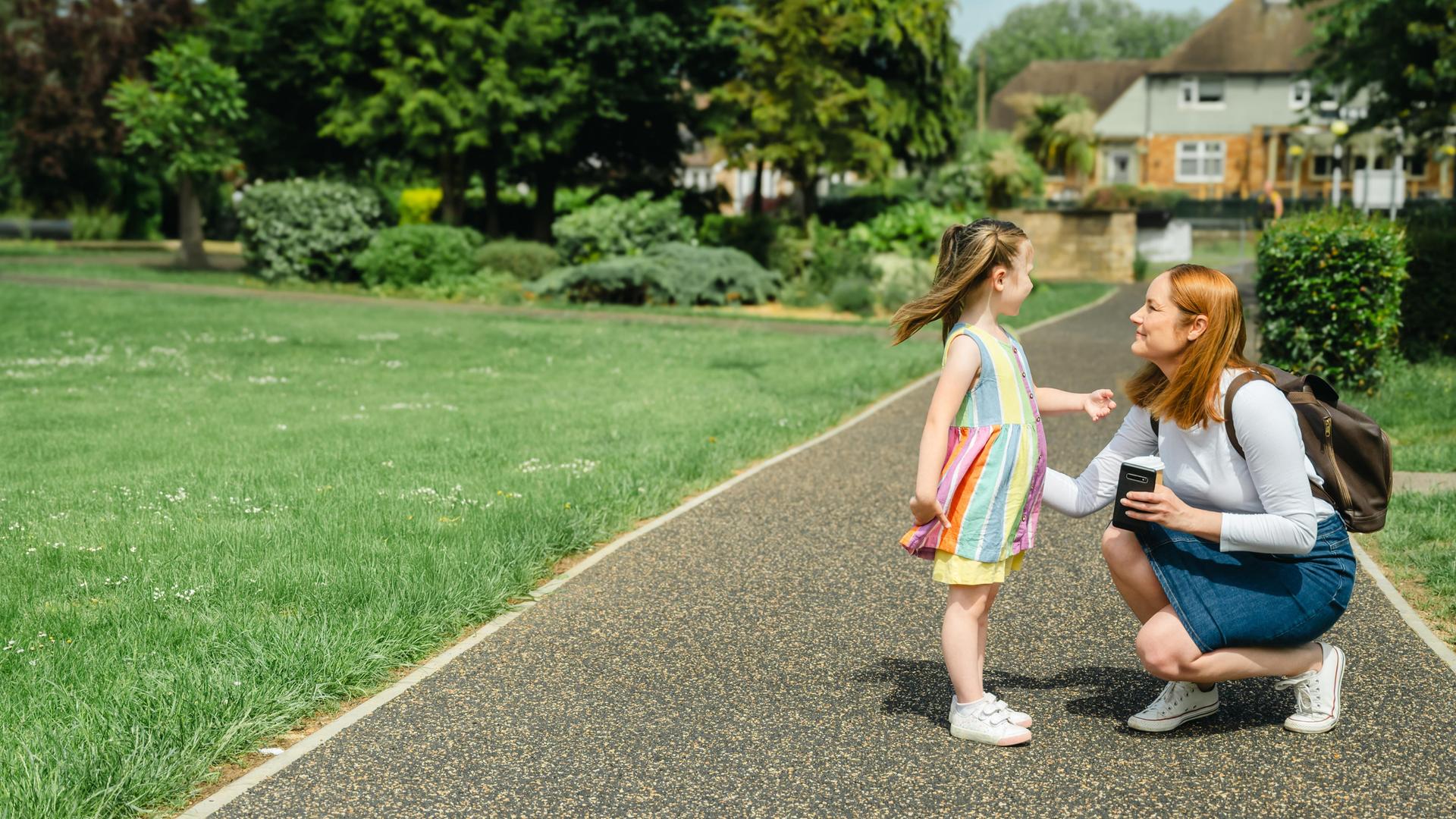 Eine Mutter spricht mit ihrer Tochter im Park Eine Mutter spricht mit ihrer Tochter im Park
